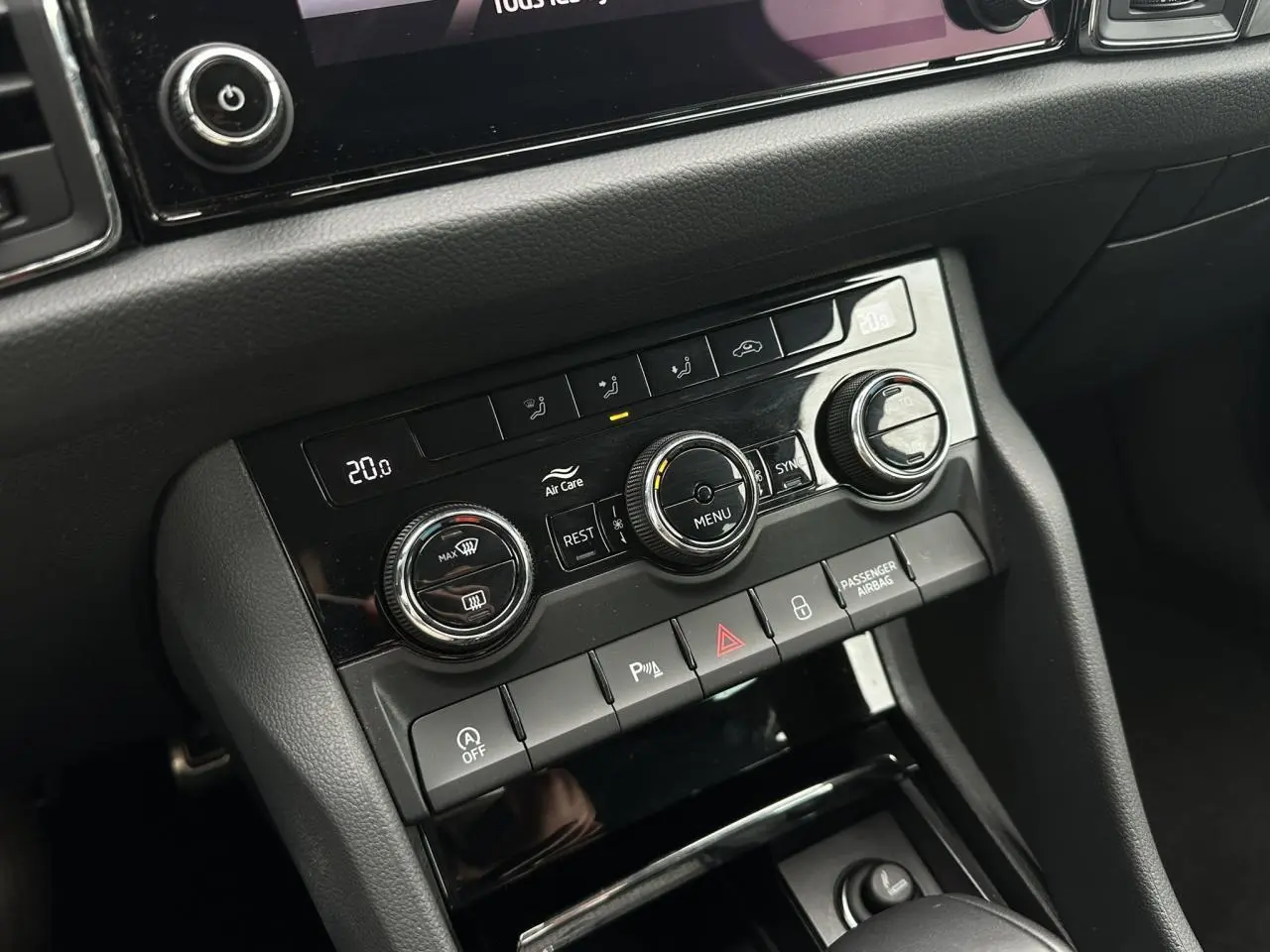 Panneau de commande de la climatisation bi-zone et boutons de sécurité dans l'habitacle du Skoda Kodiaq blanc Glacier 2024.