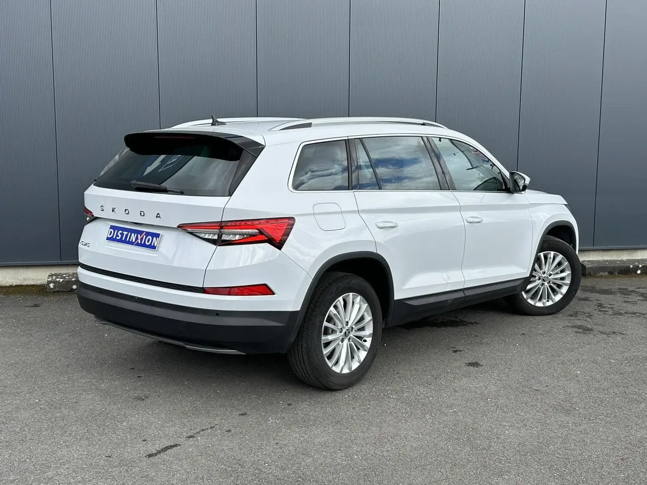 Vue 3/4 arrière droite d'un Skoda Kodiaq blanc Glacier avec jantes alliage 18 pouces et feux arrière LED.