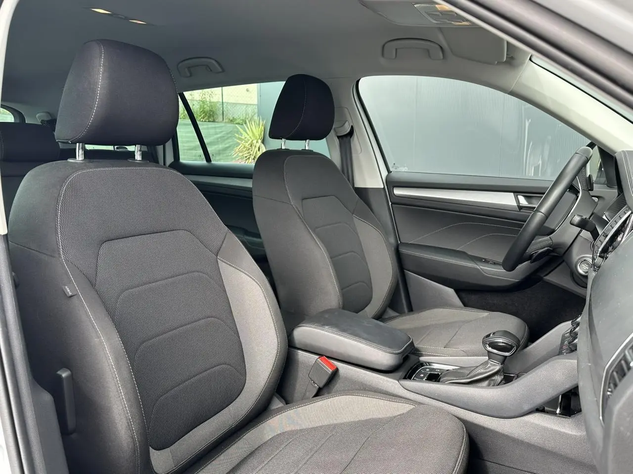 Intérieur avant du Skoda Kodiaq 2024, vue côté droit montrant sièges tissu gris et console centrale avec boîte auto.