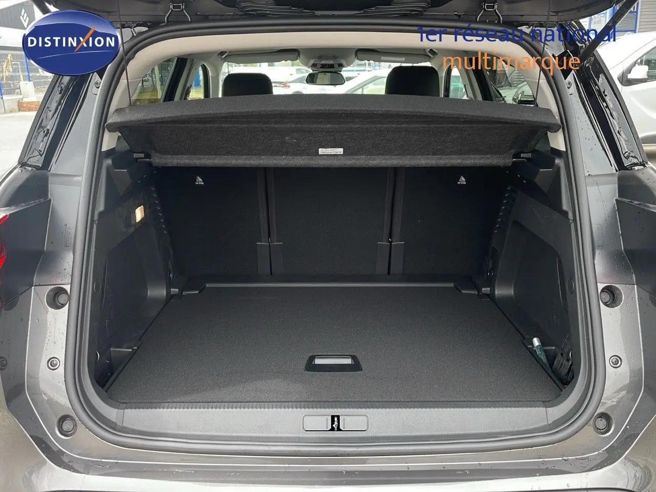 Coffre ouvert d'un Citroën C5 Aircross 2025 gris platinium métal avec toit noir, vue arrière montrant l'espace de chargement.