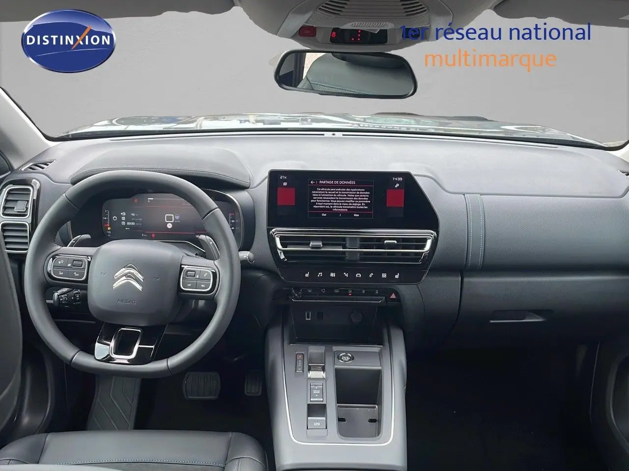 Vue intérieure avant du Citroën C5 Aircross 2025, tableau de bord gris avec écran tactile central et volant multifonction.