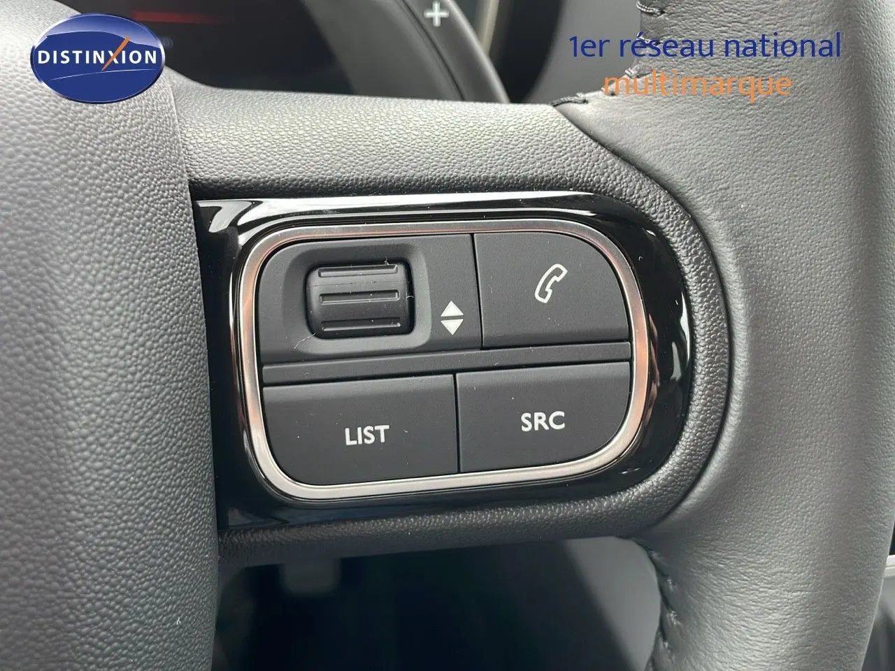 Gros plan sur les commandes du volant en cuir noir du Citroën C5 Aircross gris platinium et toit noir, version 2025.