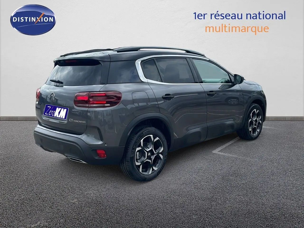 Vue 3/4 arrière droite d'un Citroën C5 Aircross gris platinium avec toit noir et jantes distinctives biton.