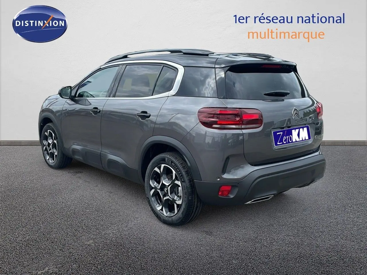 Vue 3/4 arrière droite du Citroën C5 Aircross 2025 gris platinium métal avec toit noir et jantes biton.