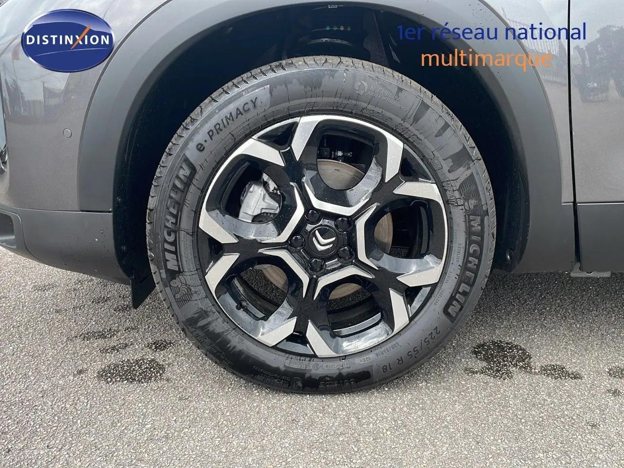 Gros plan sur la roue avant gauche du Citroën C5 Aircross gris platinium avec jante alliage bicolore et logo Citroën central.