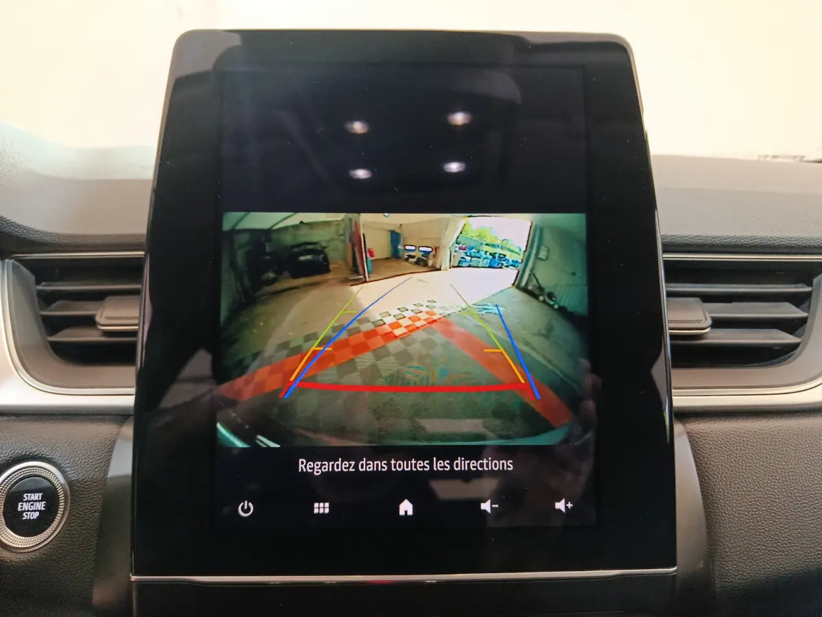 Écran tactile central du Renault Captur gris foncé 2024 montrant la caméra de recul avec guidage coloré.