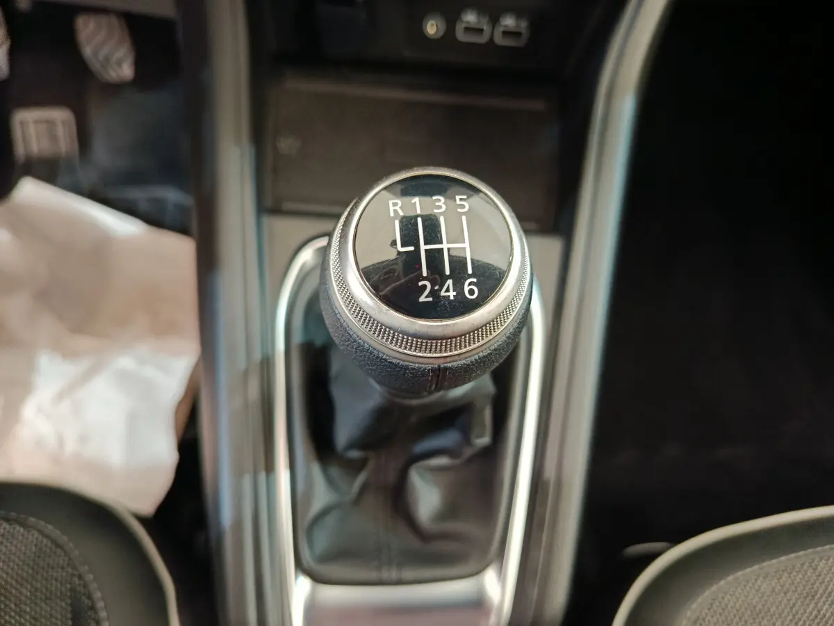 Gros plan sur le levier de vitesses manuel noir du Renault Captur Techno TCe 90 gris foncé, intérieur moderne.