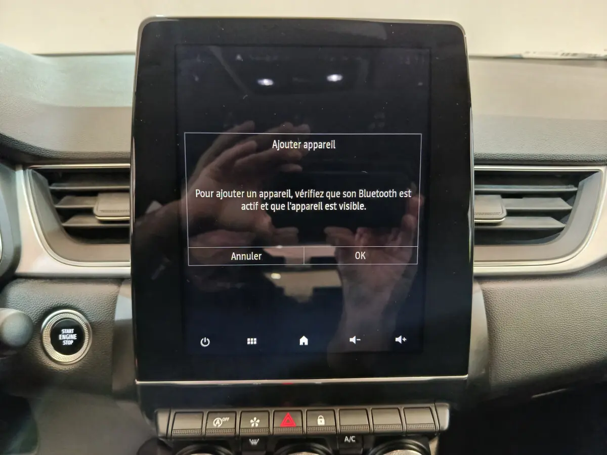 Écran tactile central allumé avec message Bluetooth sur tableau de bord noir du Renault Captur gris foncé 2024