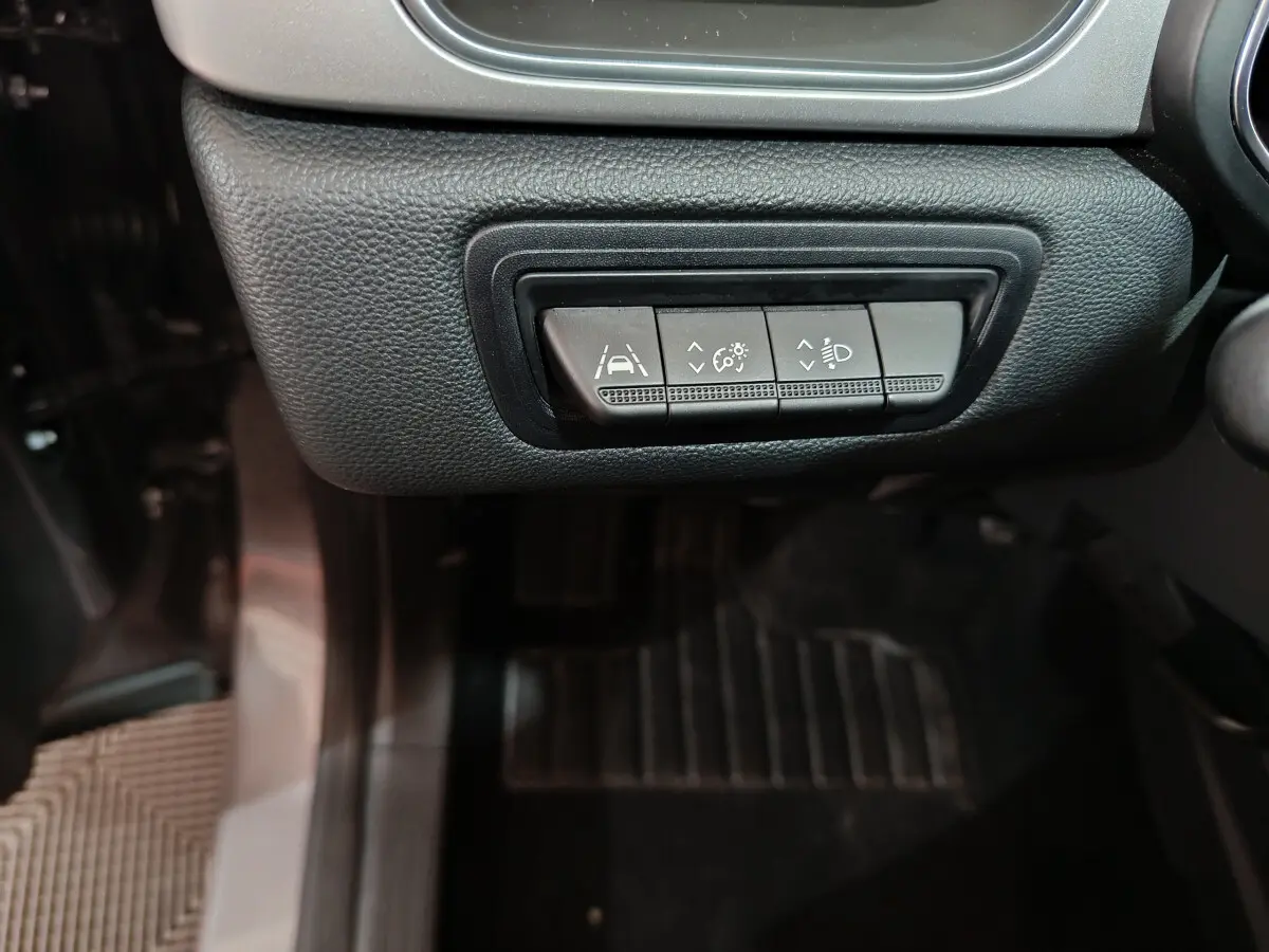 Gros plan sur les boutons de réglage des aides à la conduite et phares du Renault Captur gris foncé, côté conducteur.