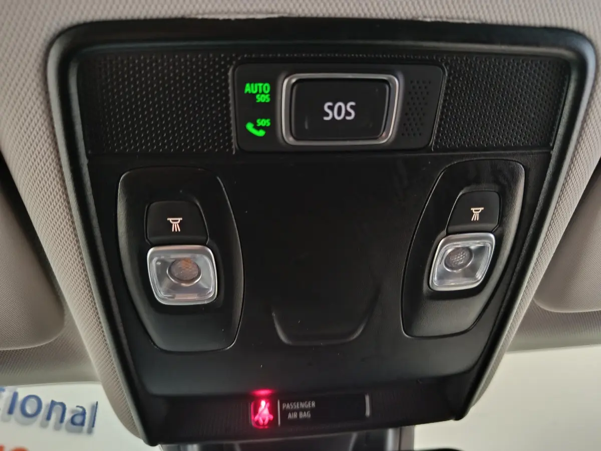 Vue en gros plan du plafonnier noir avec bouton SOS et éclairages de lecture dans un Renault Captur gris foncé 2024.