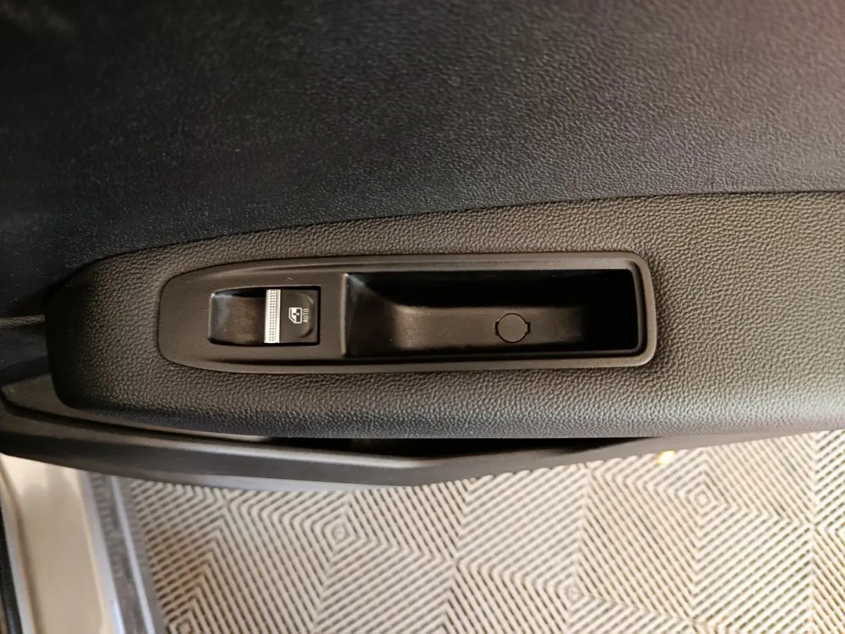 Bouton de commande de lève-vitre sur la porte côté gauche du Renault Captur gris foncé 2024.