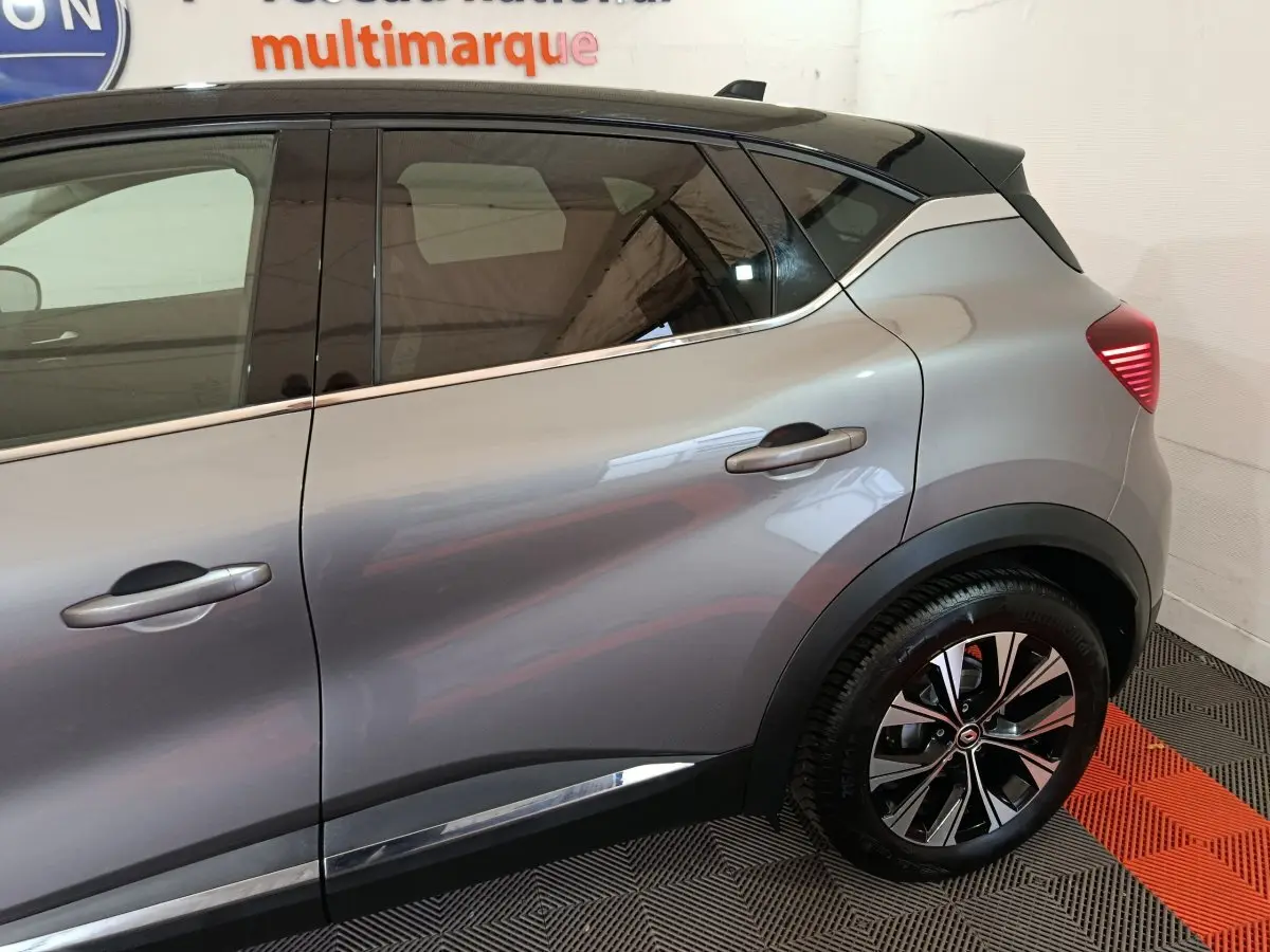 Profil droit du Renault Captur Techno TCe 90 gris foncé, mettant en valeur les jantes alliage et les poignées de porte chromées.