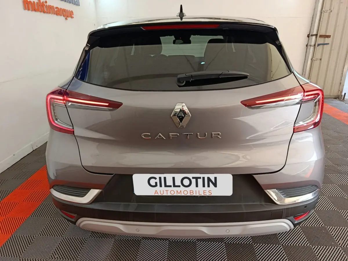 Vue arrière d'un Renault Captur gris foncé avec feux LED allumés et logo centré sur le hayon.