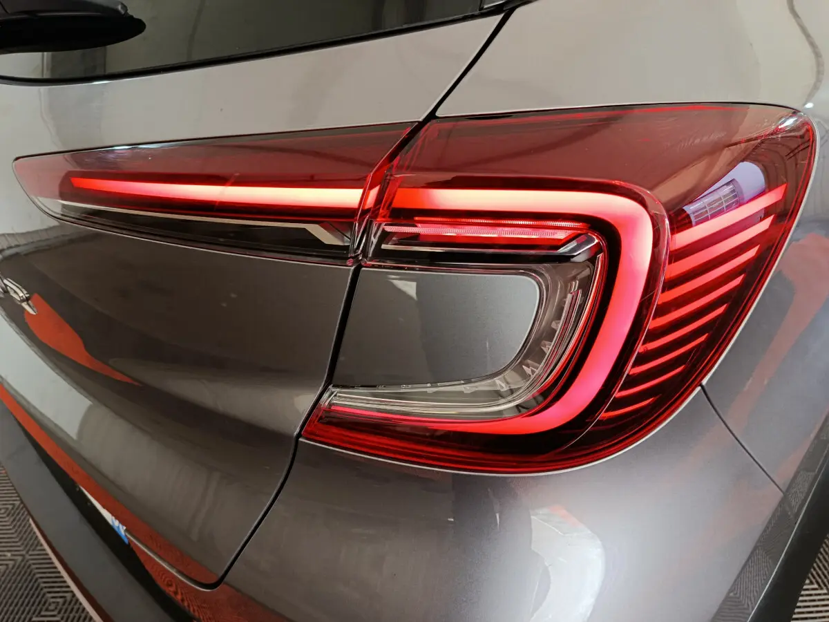 Gros plan sur le feu arrière droit allumé du Renault Captur gris foncé 2024, soulignant son design LED distinctif.