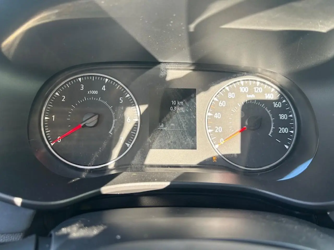 Vue rapprochée du tableau de bord de la Dacia Sandero III Stepway avec compteurs analogiques et écran numérique central.