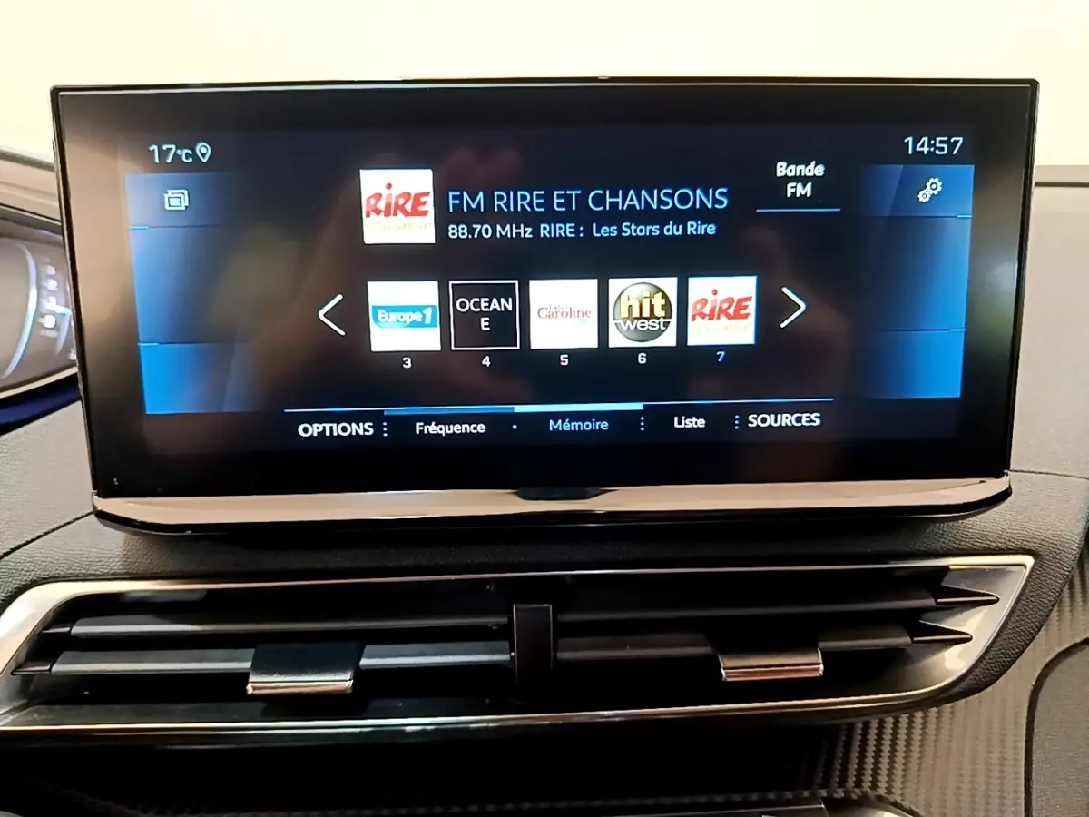 Écran tactile central affichant la radio FM dans l’habitacle du Peugeot 3008 gris foncé, vue de face.
