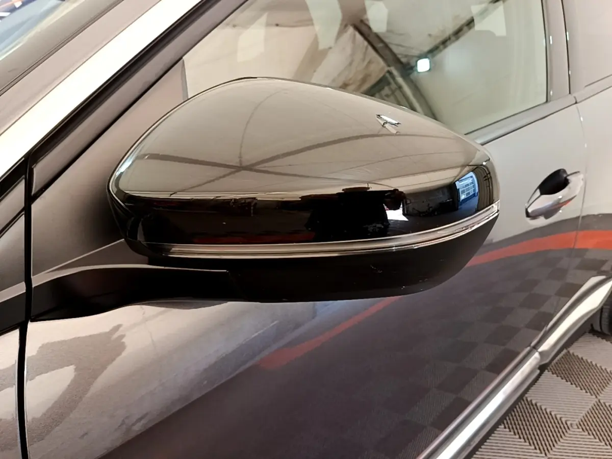 Gros plan sur le rétroviseur côté gauche d’un Peugeot 3008 gris foncé, avec clignotant intégré.