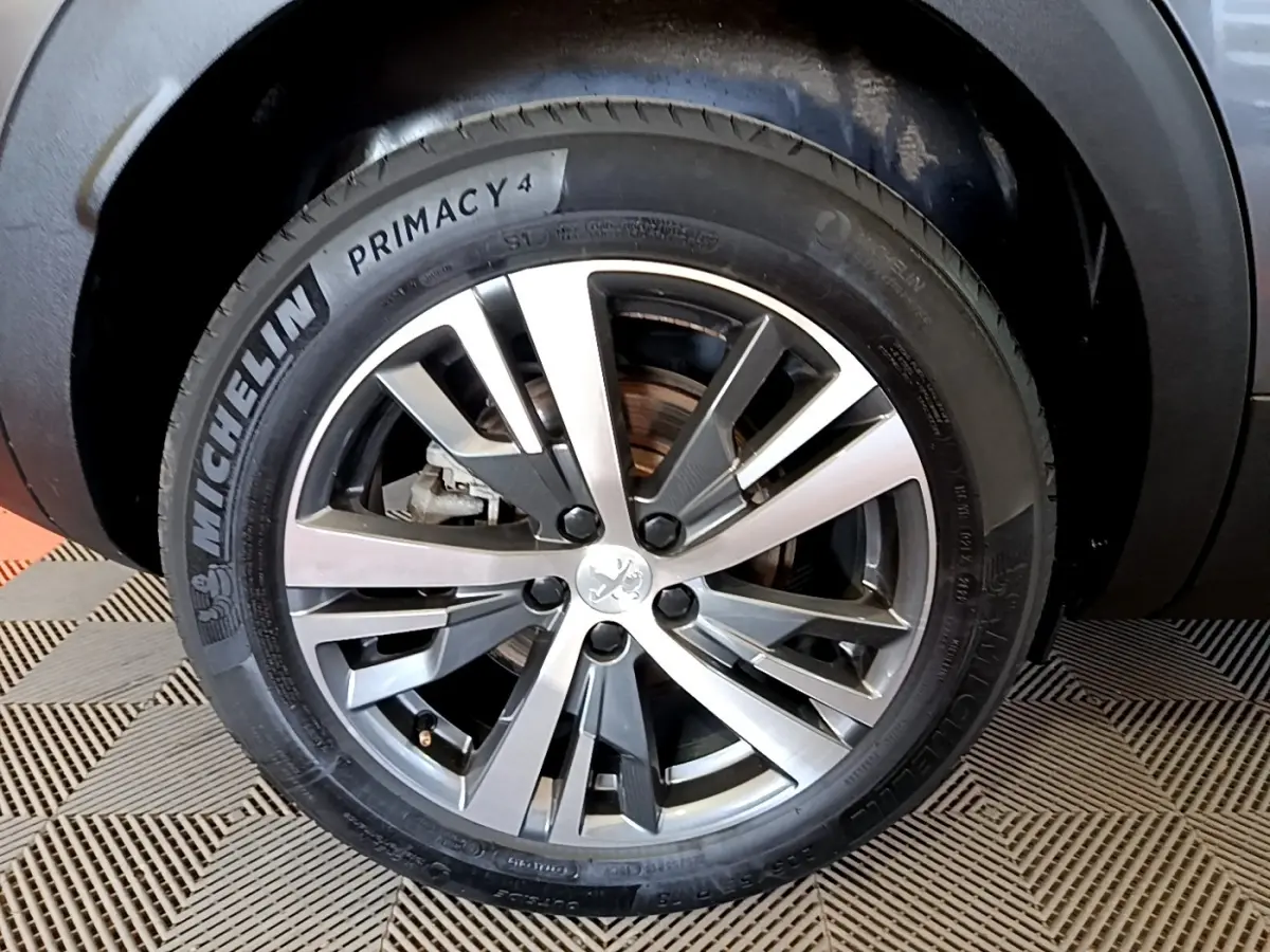 Gros plan sur la roue avant gauche du Peugeot 3008 gris foncé, avec jante alliage et pneu Michelin Primacy 4.