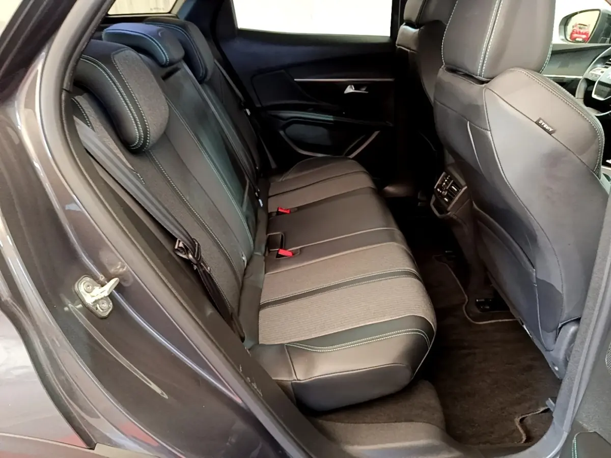 Vue côté gauche de l'intérieur arrière gris foncé du Peugeot 3008 avec sièges en cuir et tissu, et appuie-têtes visibles.