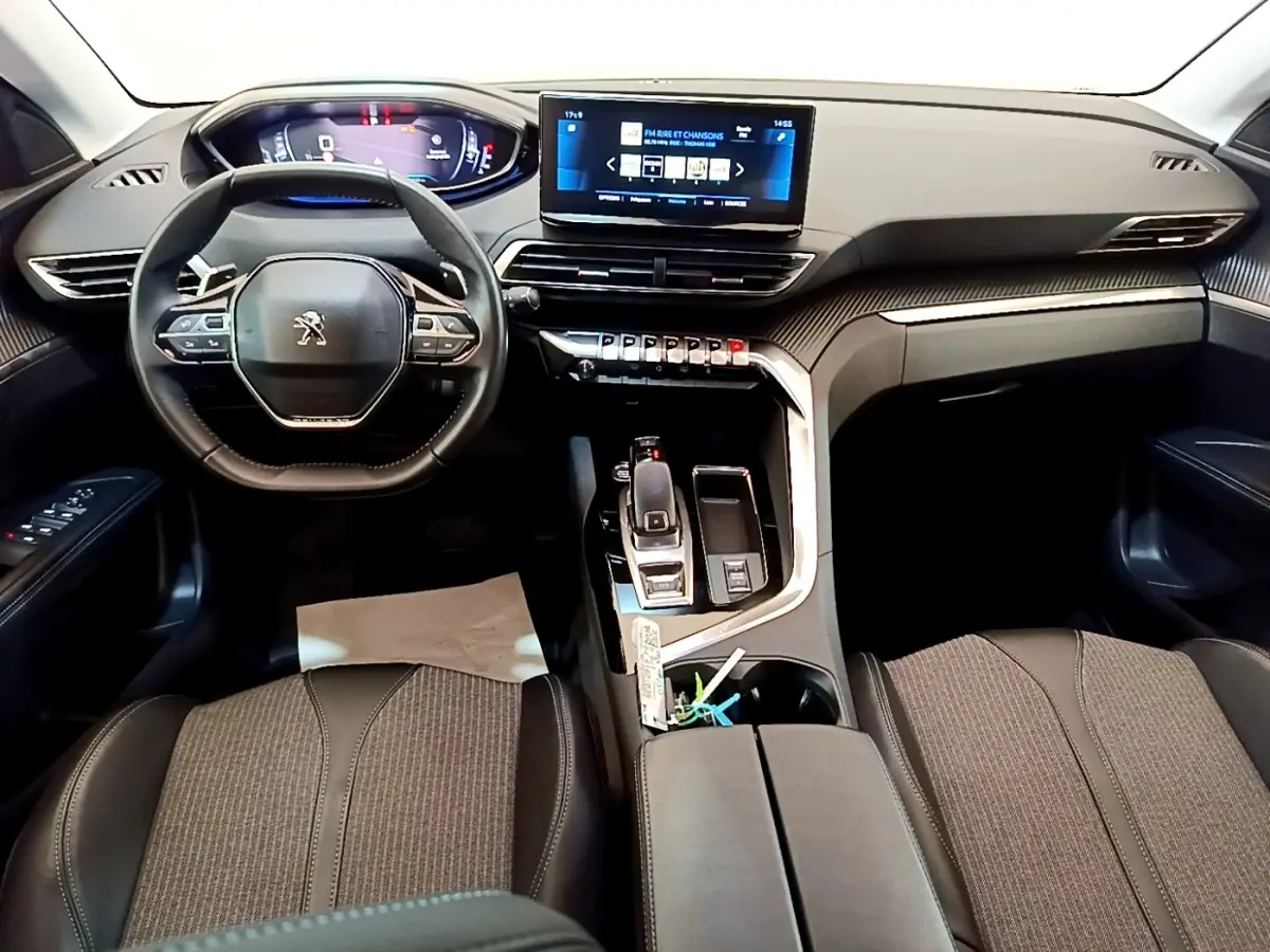 Vue intérieure avant du Peugeot 3008 2022 gris foncé, avec tableau de bord digital et écran tactile central.