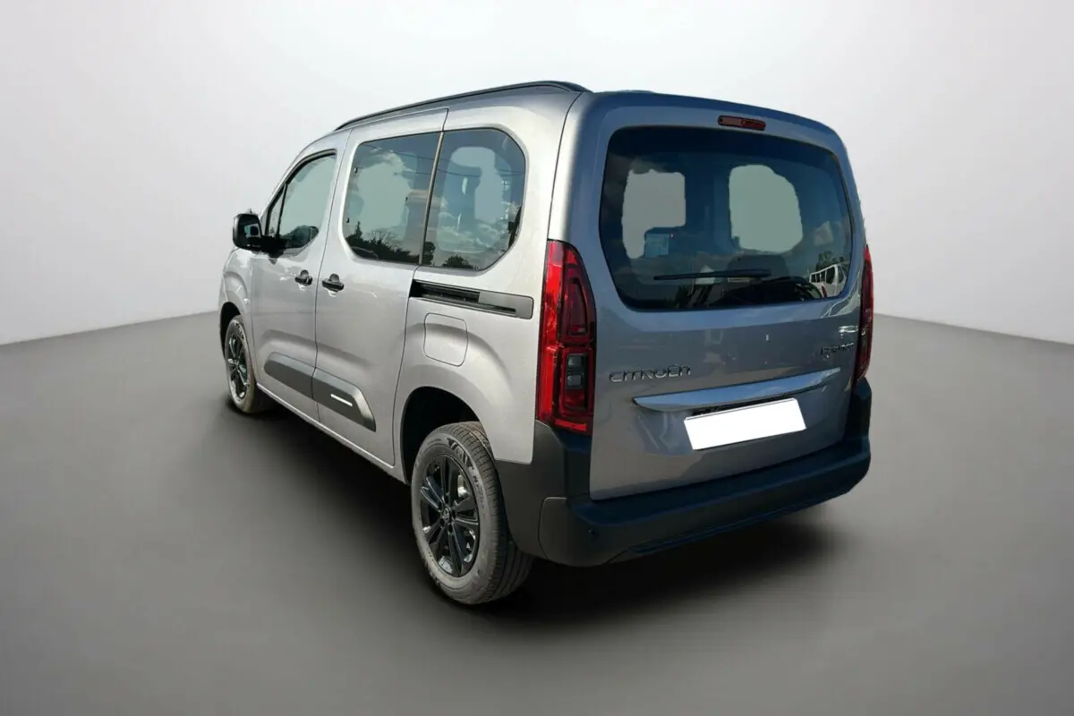 Vue 3/4 arrière gauche d'un Citroën Berlingo 2025 gris artense avec vitres teintées et jantes noires.