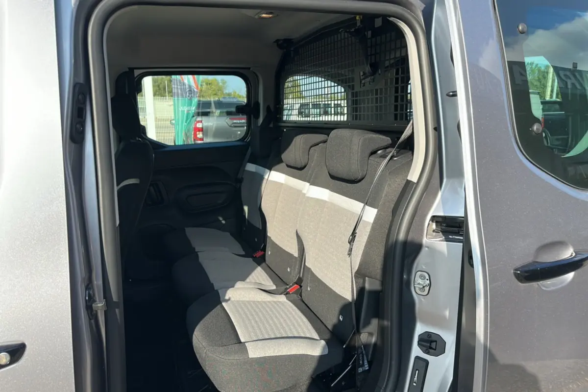 Intérieur arrière du Citroën Berlingo 2025 gris Artense, vue côté droit sur les sièges tissu bicolore et la grille de séparation.