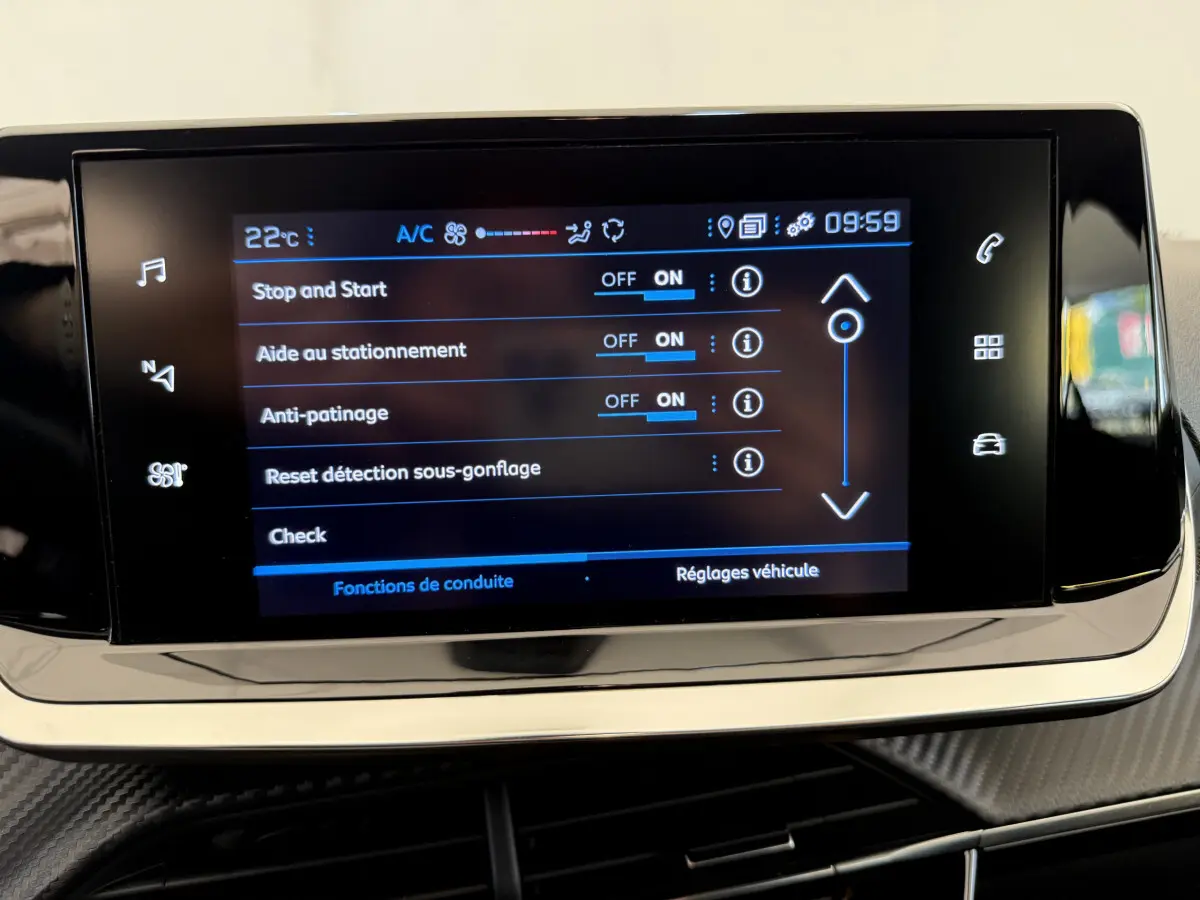 Écran tactile central affichant les réglages de conduite dans l'habitacle d'une Peugeot 208 noire de 2021.