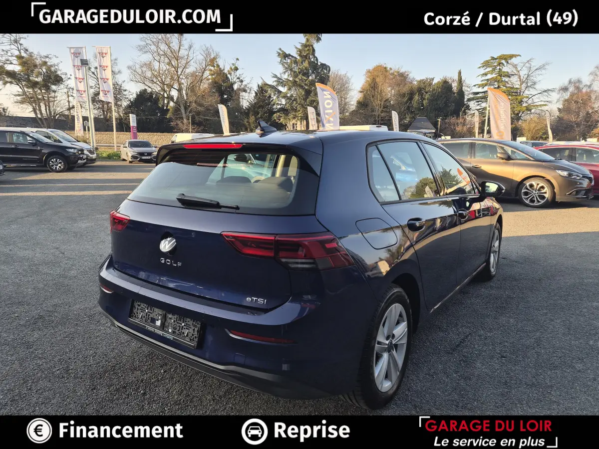 Vue 3/4 arrière droite d'une Volkswagen Golf bleu nuit 2023 avec feux arrière LED et jantes alliage.