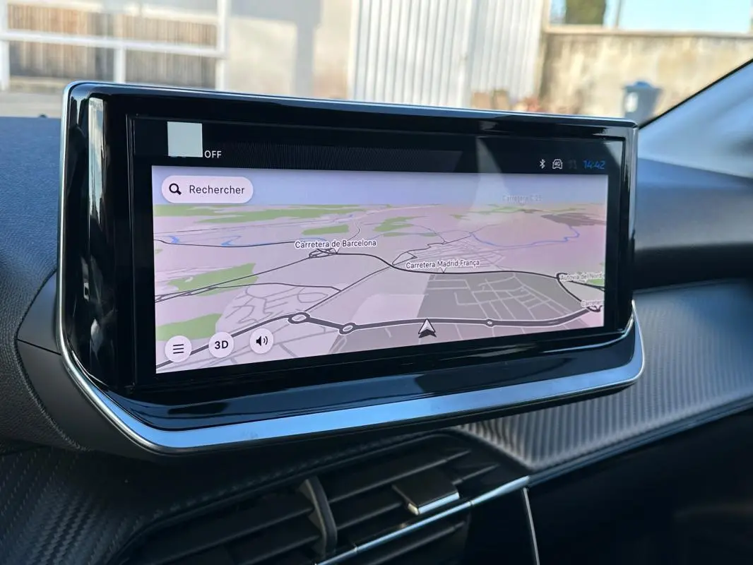 Écran tactile de navigation intégré au tableau de bord d'une Peugeot 208 Hybrid 110 blanc, vue intérieure.