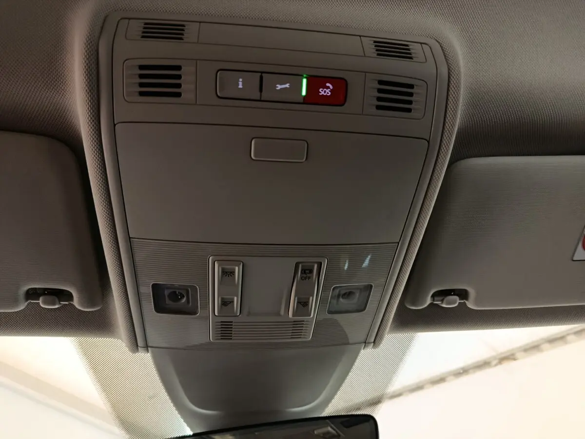 Vue intérieure du plafond de la Volkswagen Taigo gris foncé 2023, avec commandes d’éclairage et bouton SOS éclairé.