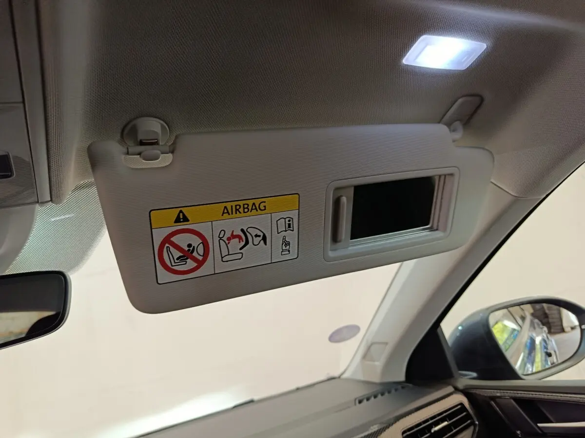 Vue intérieure du pare-soleil côté conducteur avec miroir et avertissement airbag dans un Volkswagen Taigo 2023.