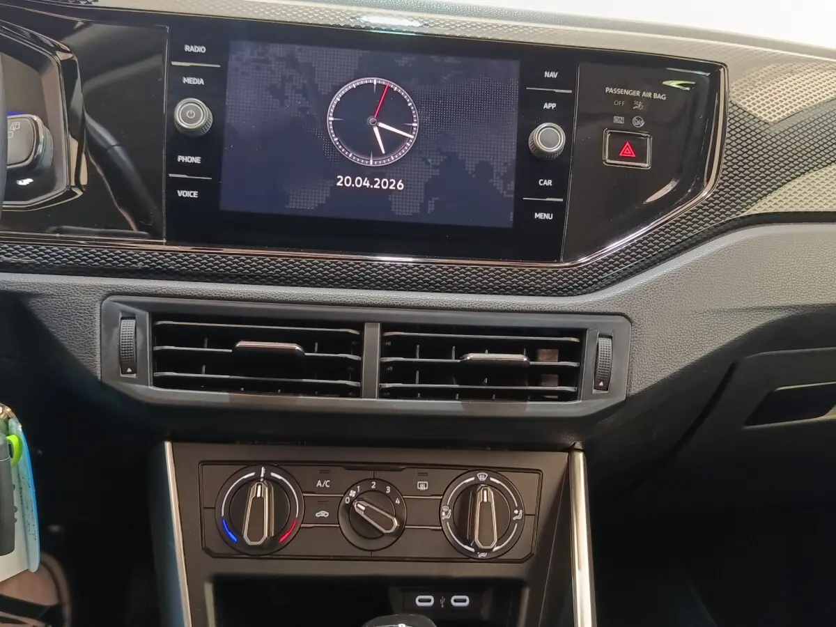 Vue rapprochée du tableau de bord du Volkswagen Taigo 2023, écran tactile central affichant une horloge digitale.