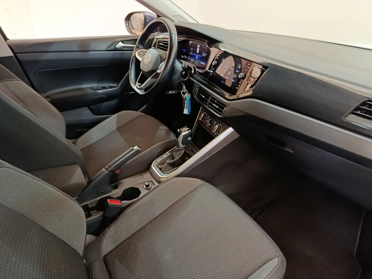 Intérieur avant droit du Volkswagen Taigo gris foncé 2023, avec tableau de bord numérique et écran tactile central.