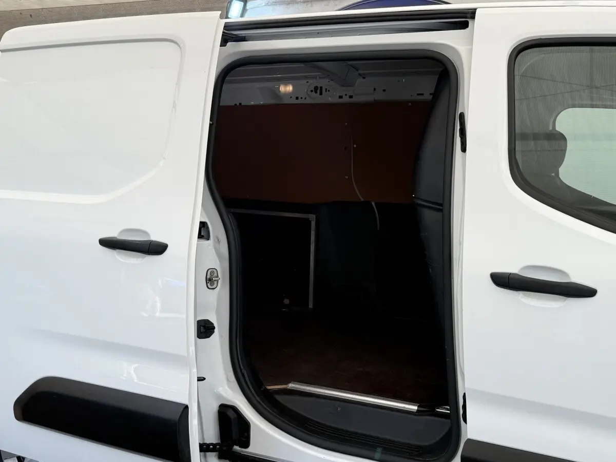 Vue latérale gauche sur la porte coulissante ouverte du Toyota Proace City blanc, montrant l’espace de chargement intérieur.