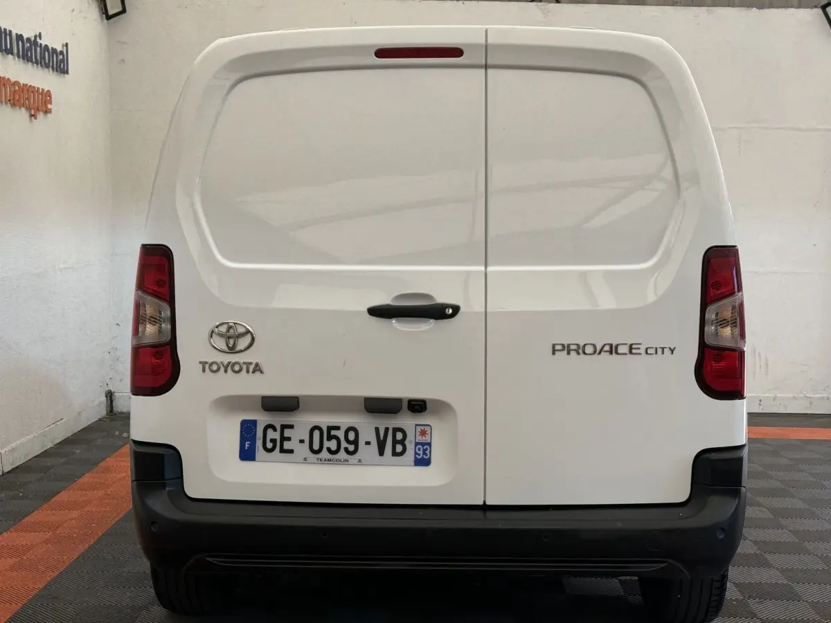 Vue arrière du Toyota Proace City blanc avec portes battantes et plaque d'immatriculation française visible.