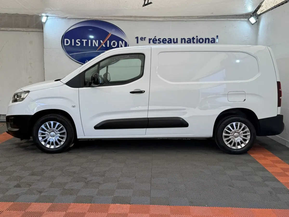 Vue de profil côté gauche du Toyota Proace City blanc, fourgon utilitaire avec jantes acier et protections noires.