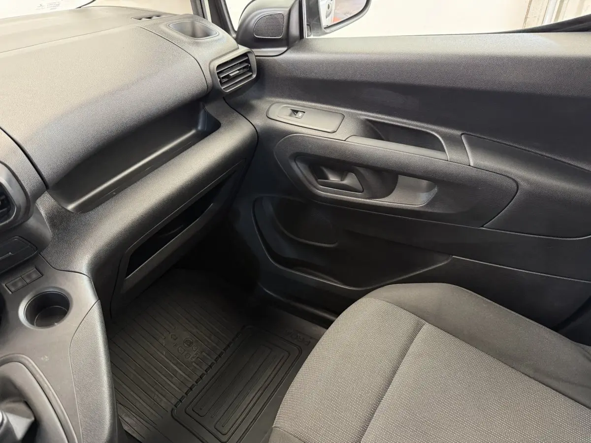 Intérieur côté passager du Toyota Proace City 2022, avec tableau de bord et porte en plastique noir.