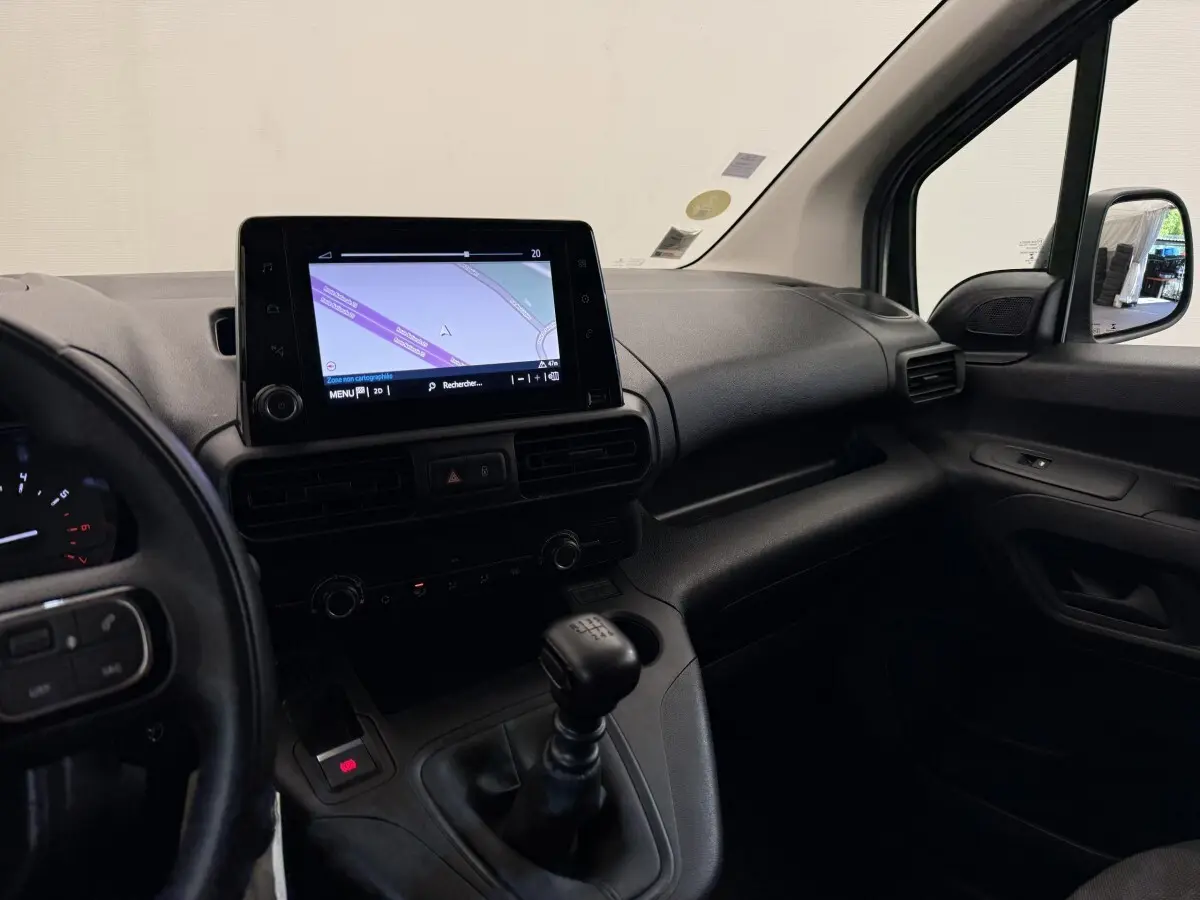 Vue intérieure côté passager du tableau de bord noir du Toyota Proace City avec écran tactile et levier de vitesses manuel.