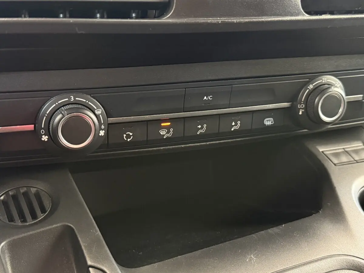Détail du tableau de bord noir avec commandes de climatisation du Toyota Proace City blanc, version 2022.