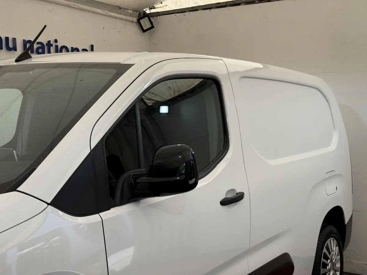 Vue de profil côté gauche d’un Toyota Proace City blanc, version utilitaire avec porte latérale pleine et rétroviseur noir.