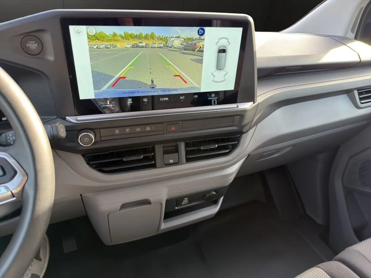Vue intérieure du tableau de bord du Volkswagen Transporter 2025 avec écran tactile affichant la caméra de recul.