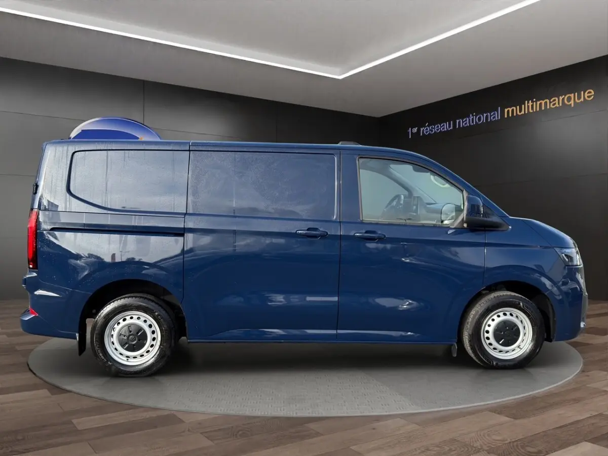 Vue de profil côté droit du Volkswagen Transporter bleu 2025, fourgon utilitaire avec jantes acier et vitres teintées.