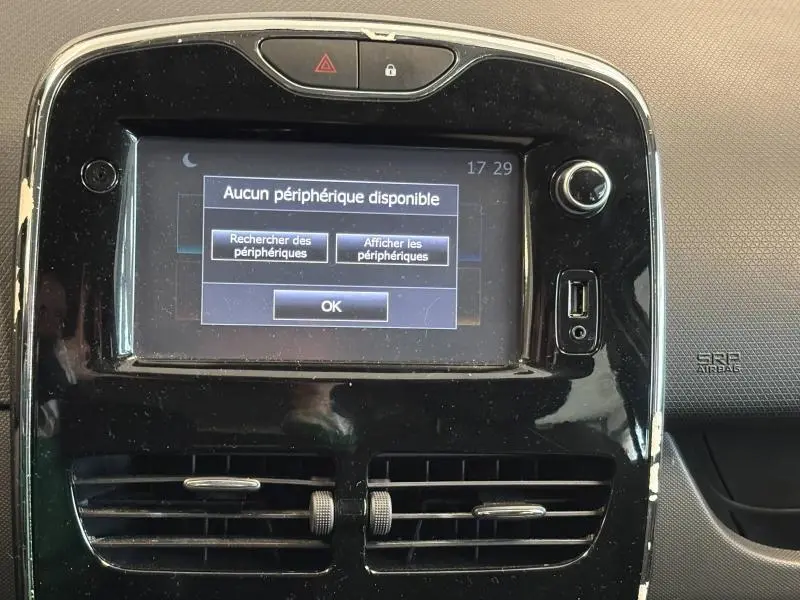 Écran tactile central de la Renault Clio 2014 avec message d'aucun périphérique disponible, entouré de plastique noir brillant.