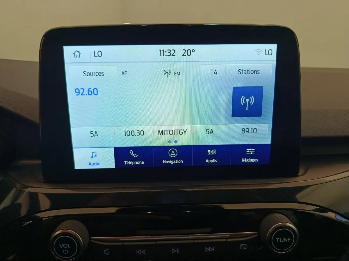 Écran tactile central affichant la radio et navigation dans le tableau de bord du Ford Kuga gris clair 2024.