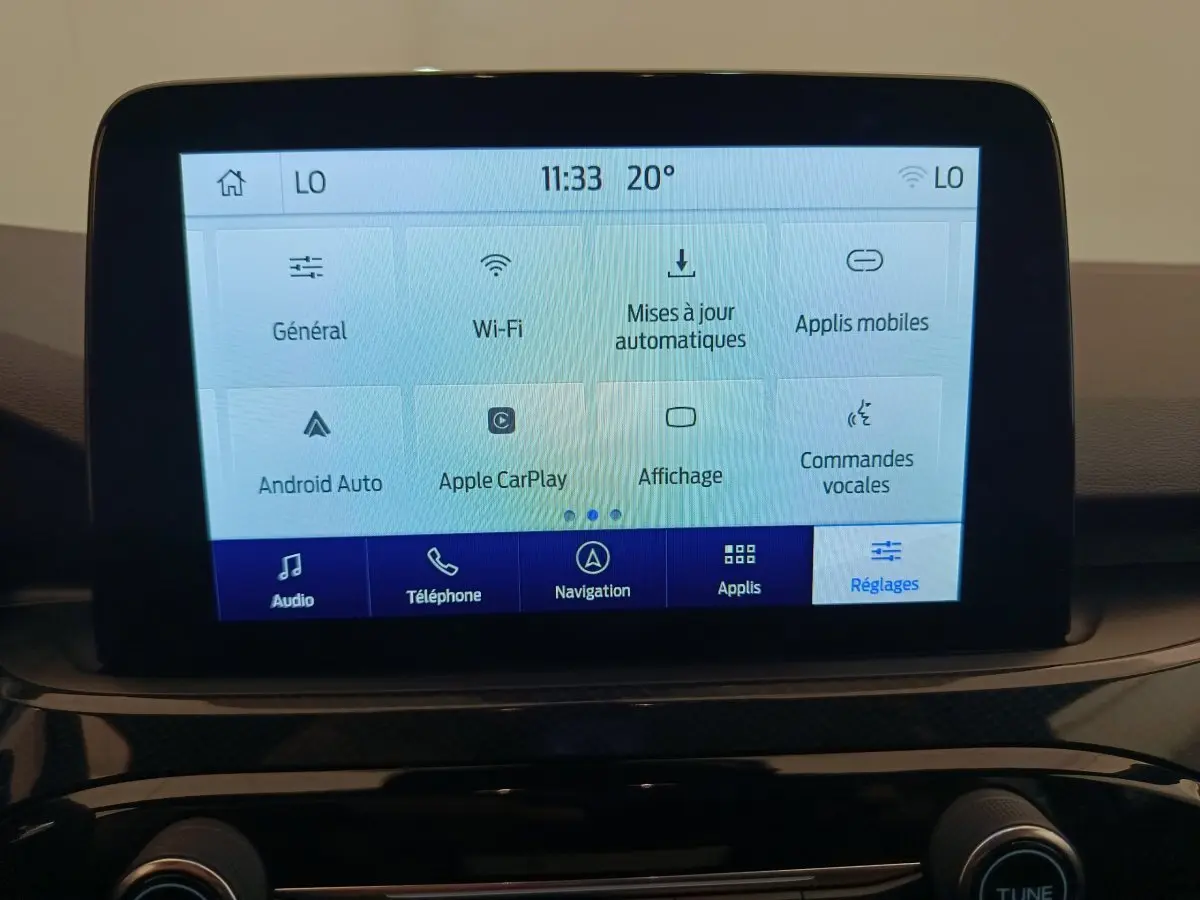 Écran tactile central du Ford Kuga 2024 affichant les réglages Wi-Fi, Apple CarPlay et commandes vocales.