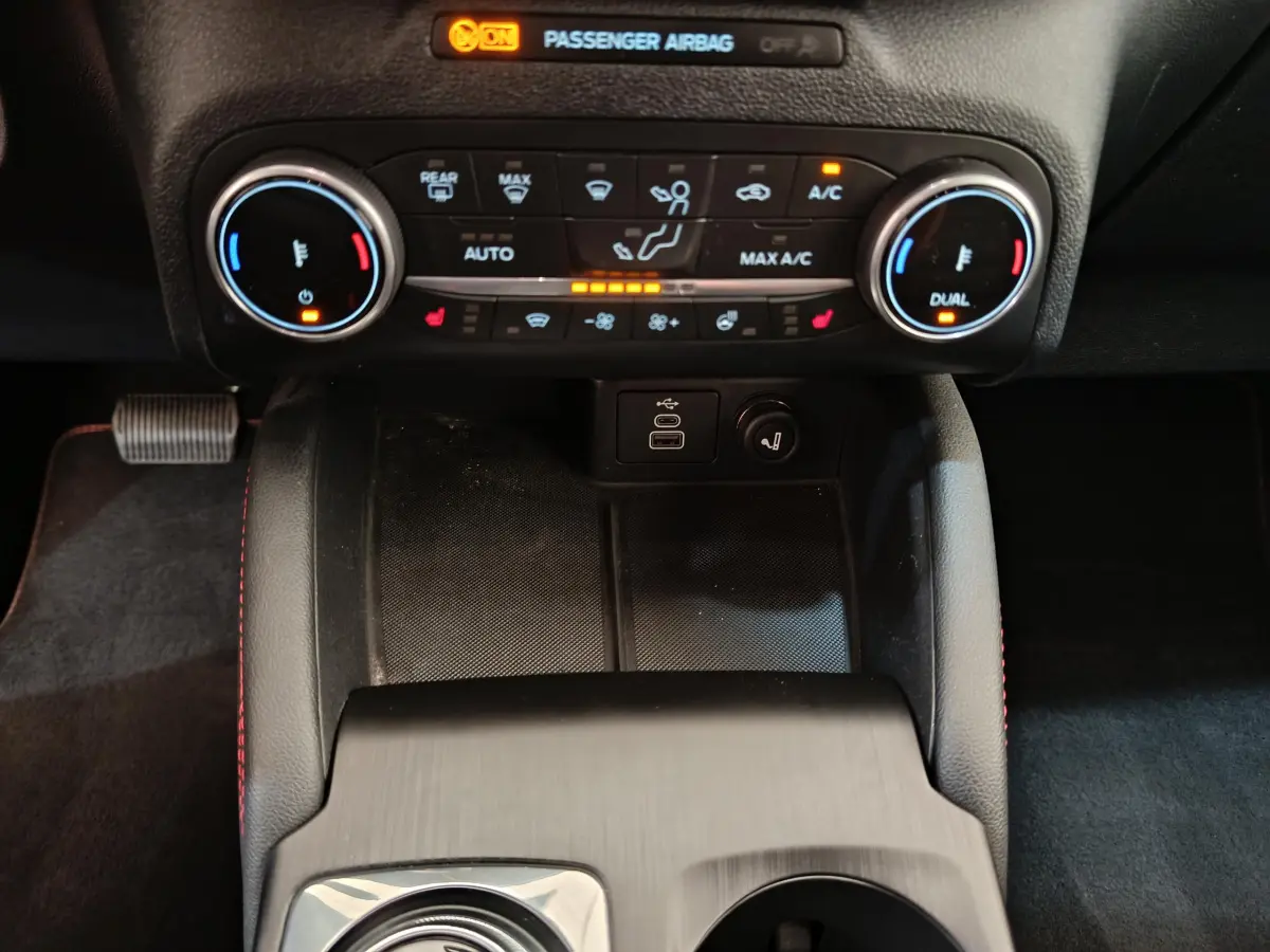 Vue rapprochée de la console centrale du Ford Kuga 2024, montrant les commandes de climatisation et ports USB.