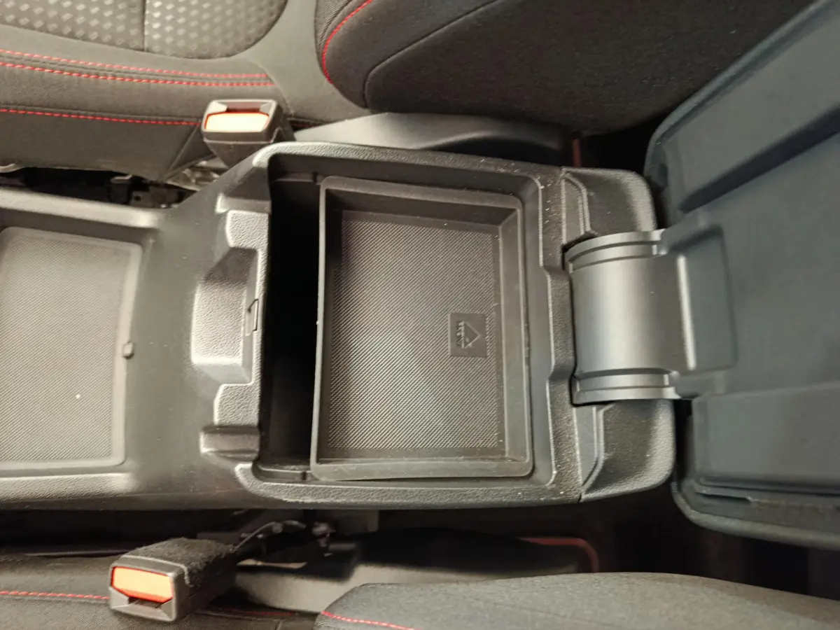 Coffre de console central ouvert avec rangement intérieur noir sur Ford Kuga gris clair 2024 St Line.