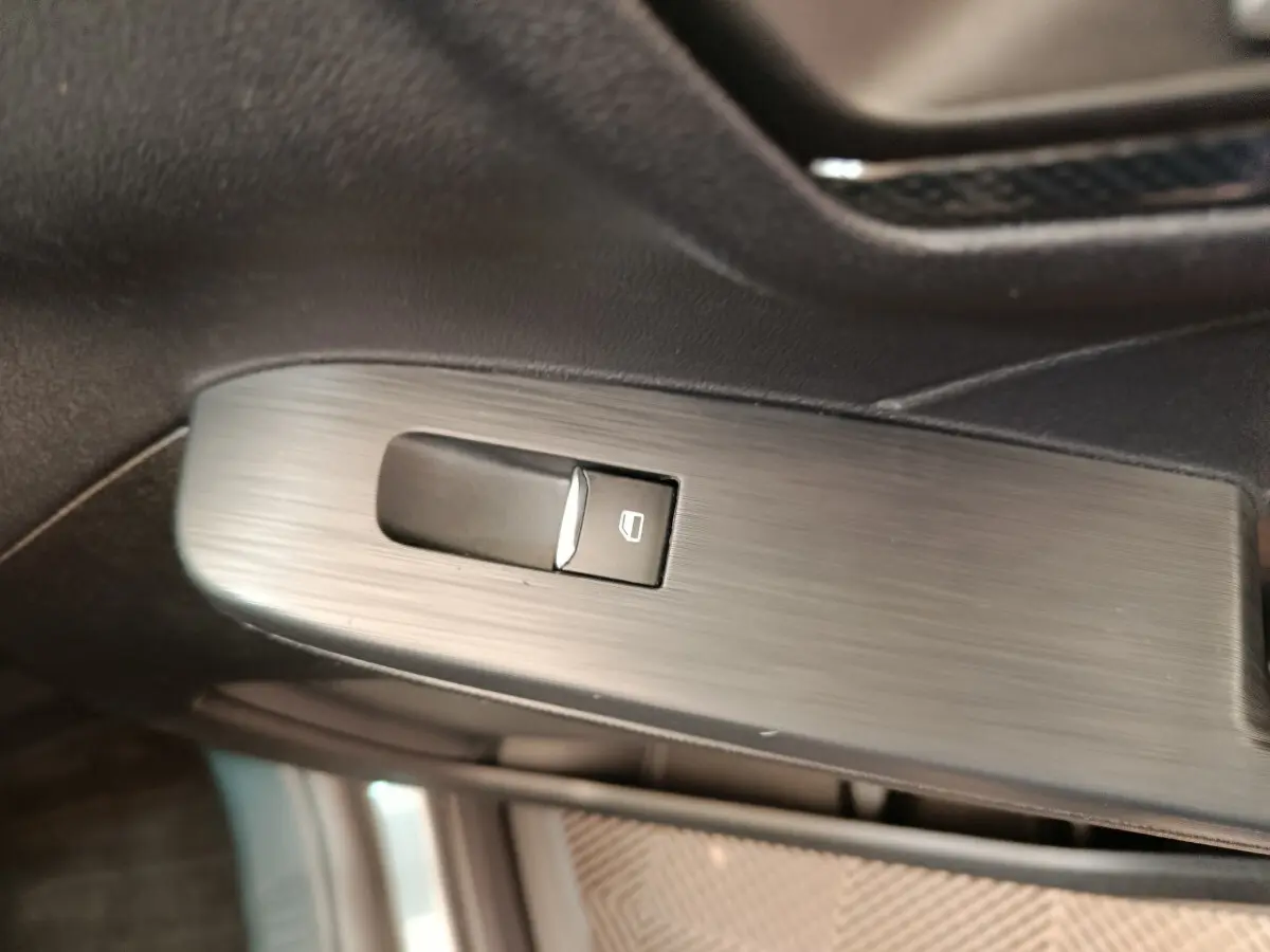 Bouton de commande de lève-vitre sur la porte intérieure côté conducteur du Ford Kuga gris clair 2024 St Line.