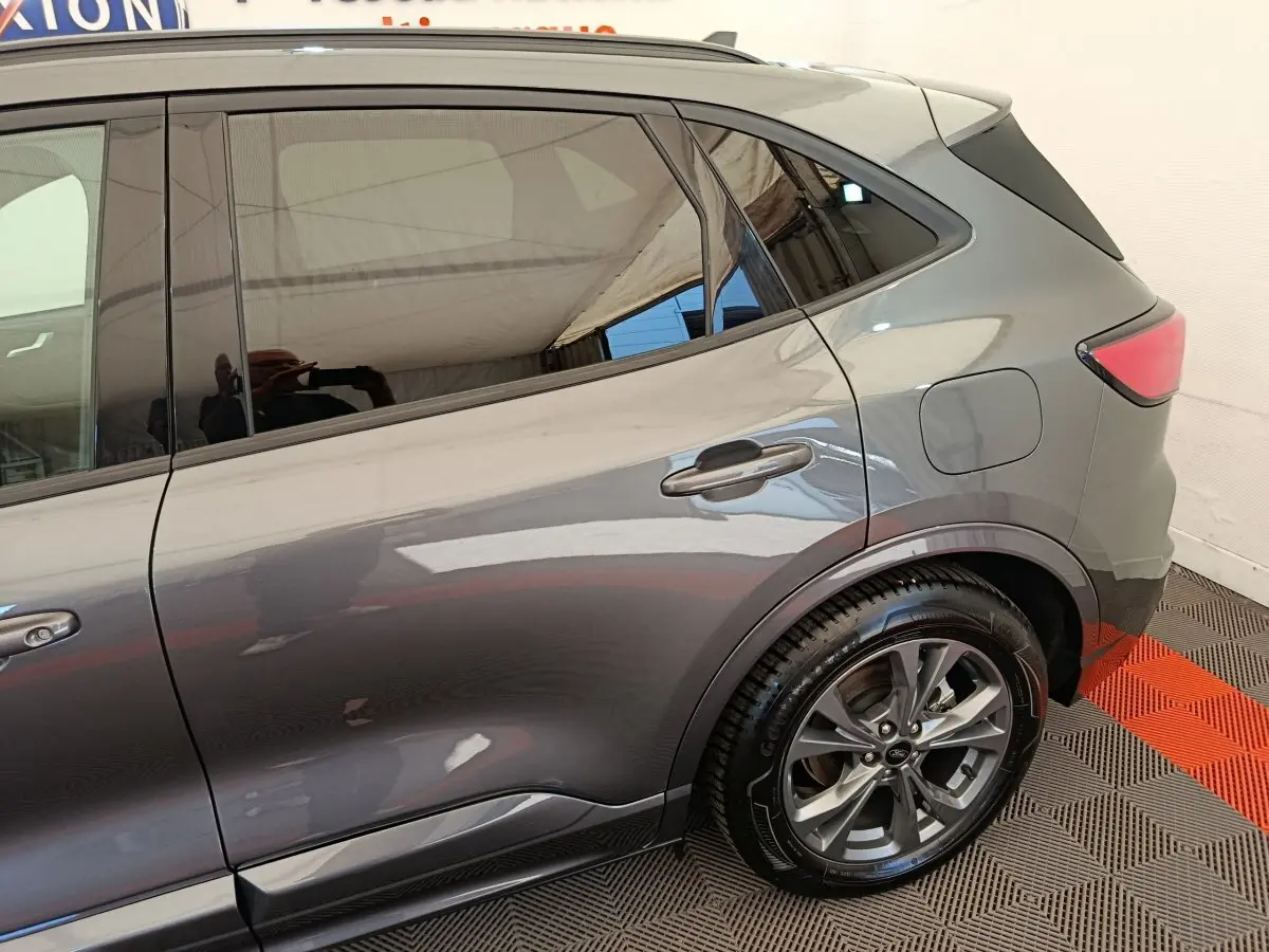 Vue latérale droite du Ford Kuga gris clair 2024 avec jante alliage et vitres teintées.