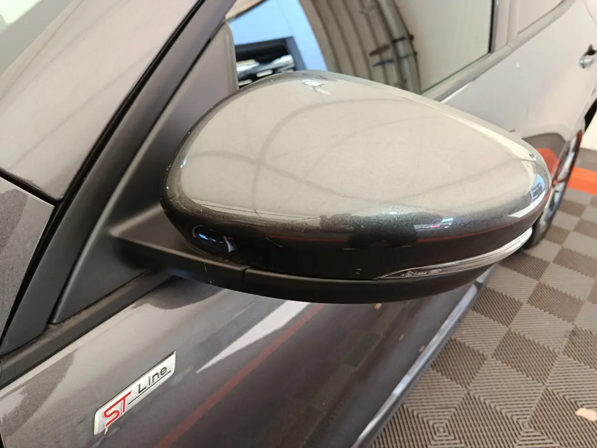 Gros plan sur le rétroviseur droit gris clair d'un Ford Kuga 2024 finition ST Line avec logo ST Line visible sur la portière.
